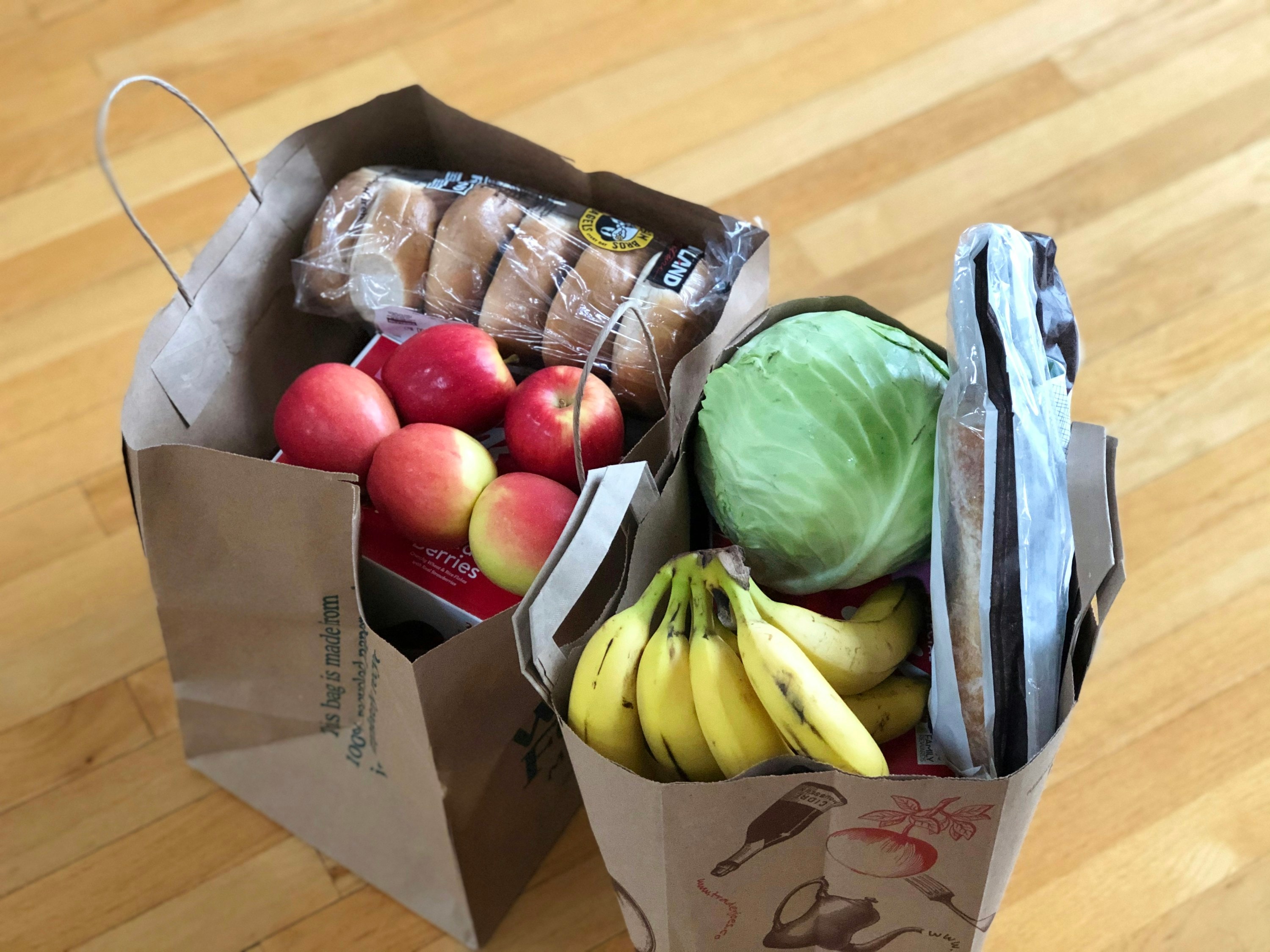 Duas sacolas de doação com frutas, verduras e pães